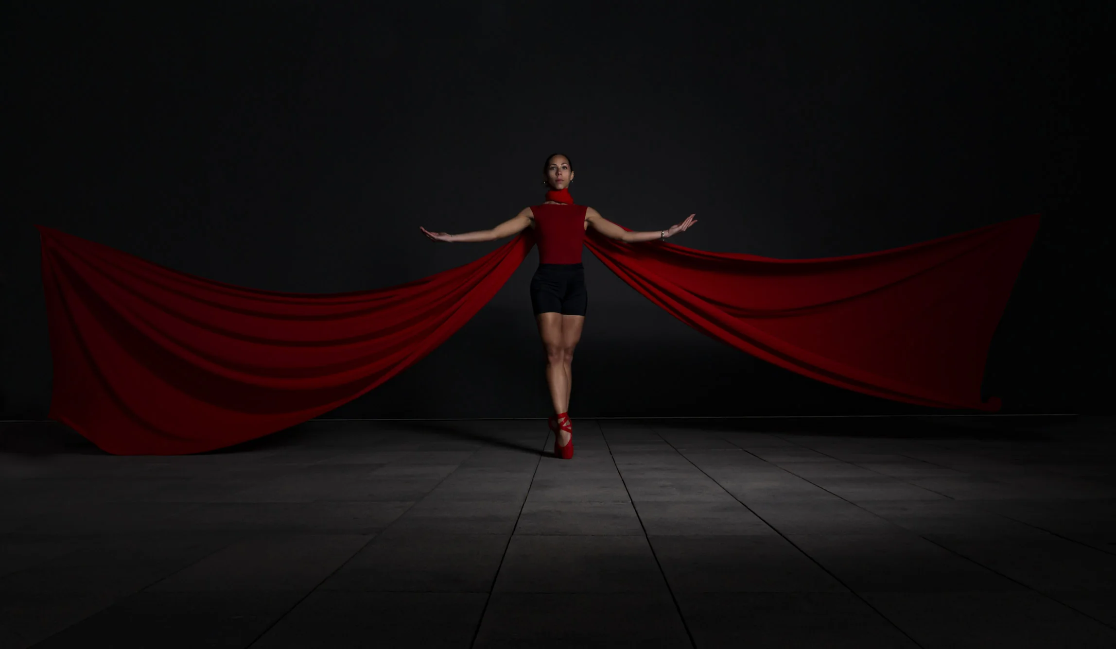 Bailarina enmarcada por una tela roja extendida