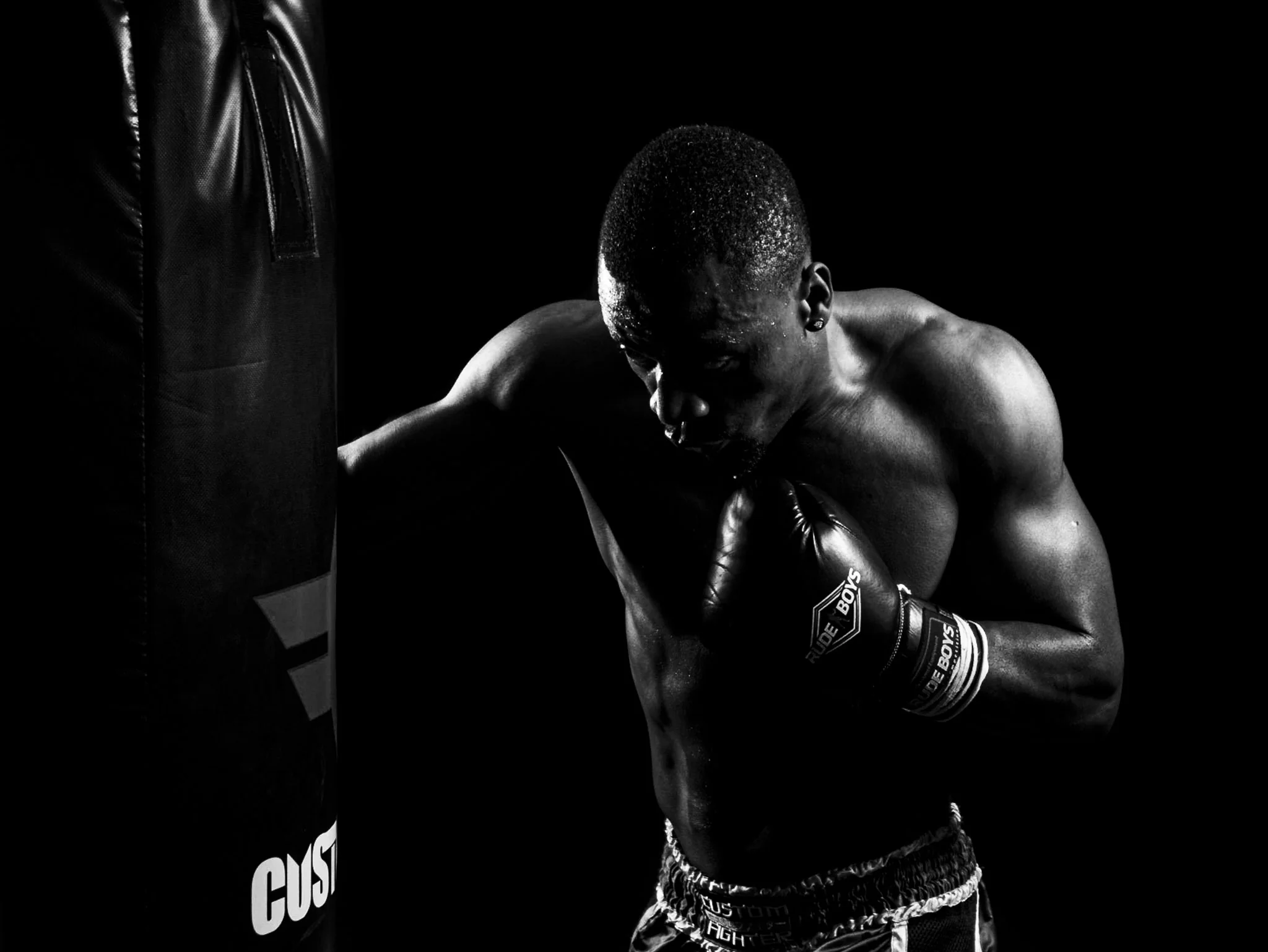 Boxeador con guantes, iluminado lateralmente en blanco y negro